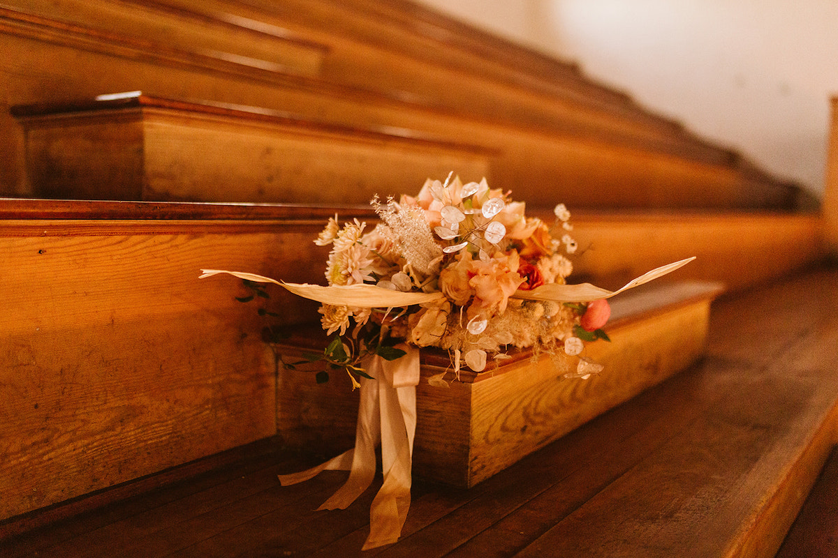 Southerly Flower Farm bridal bouquet with ribbons sitting on steps of wooden bleachers