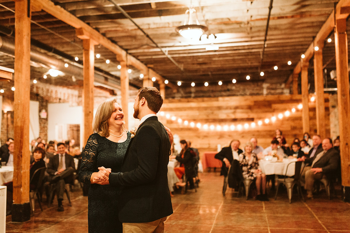 Groom and his mother dance under the exposed rafters and beams of Weaver's Room at The Old Woolen Mill in Cleveland Tennessee