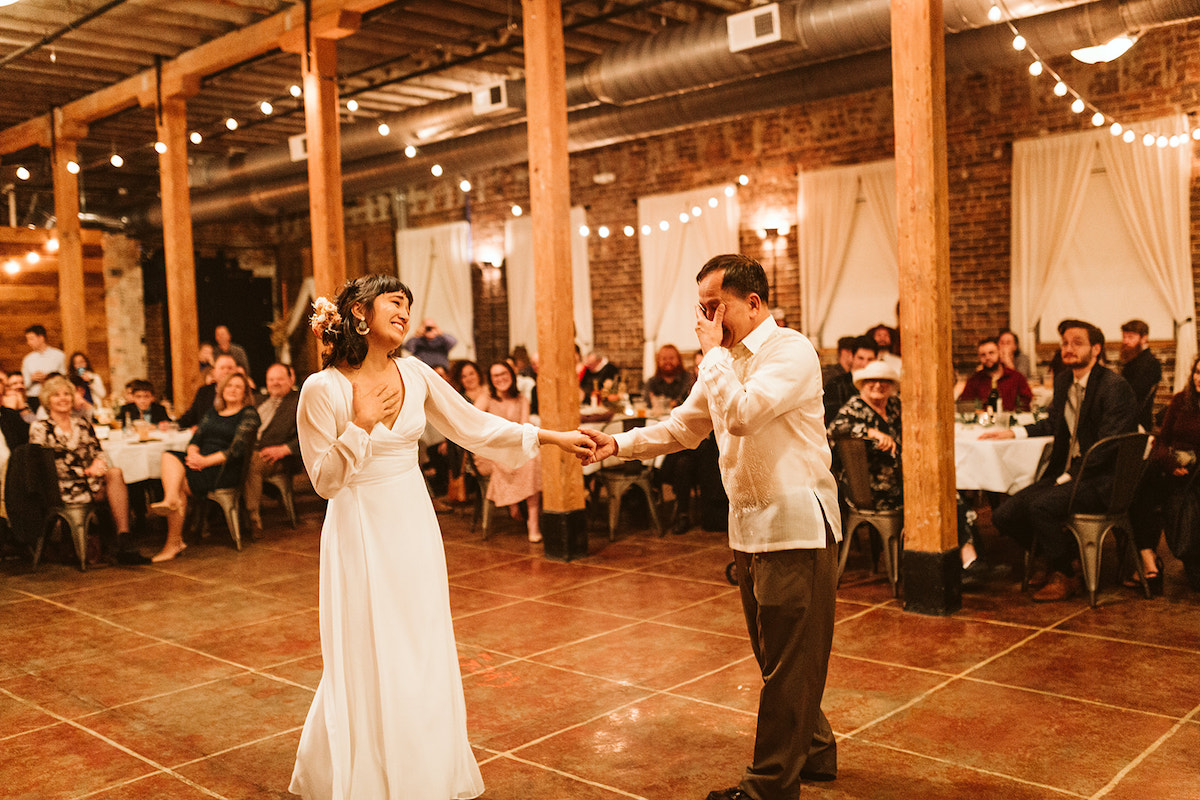 Bride and father dance under exposed rafters and beams at The Old Woolen Mill in Cleveland, TN