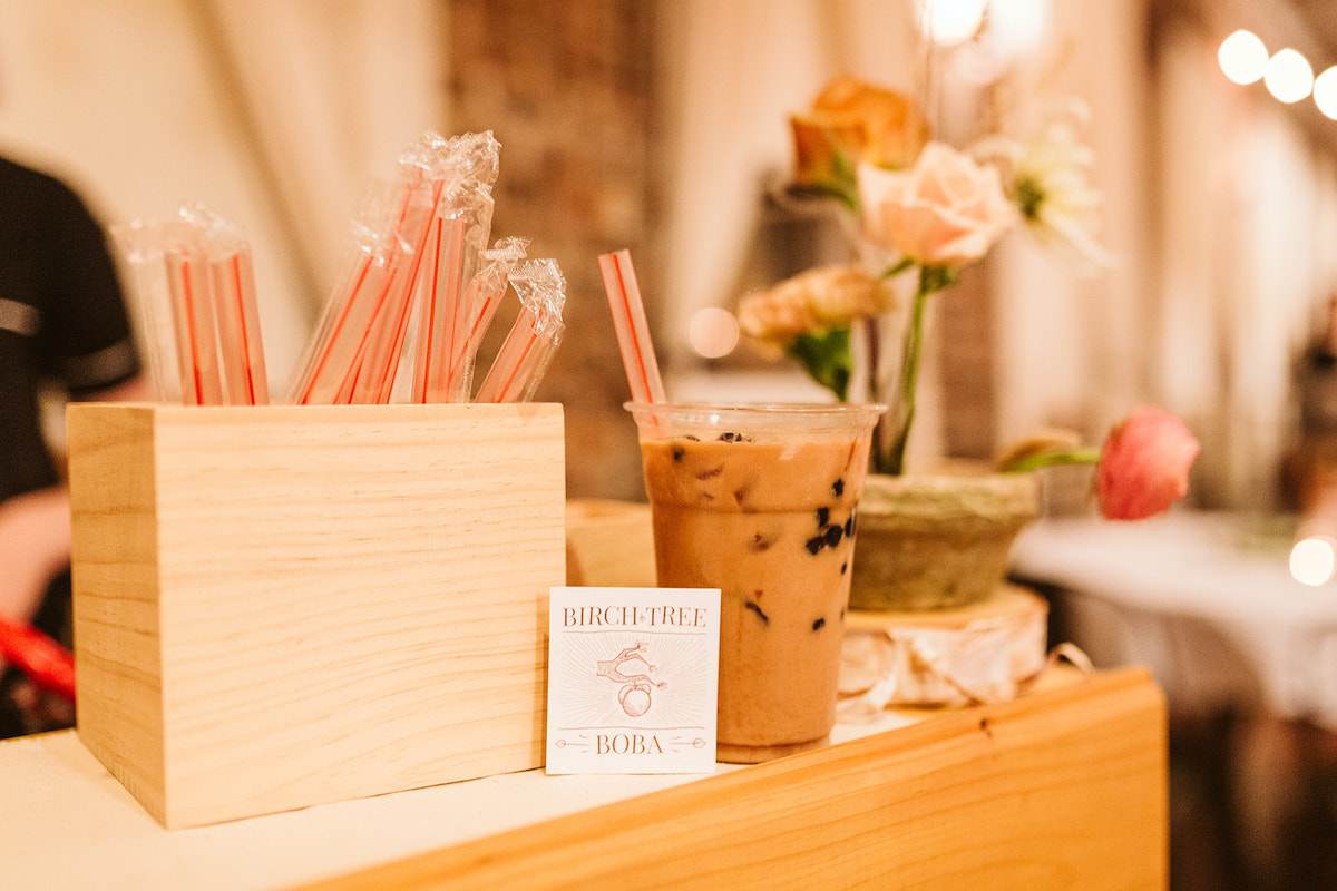 Birch Tree Boba cup of tea with dark boba pearls next to box of straws