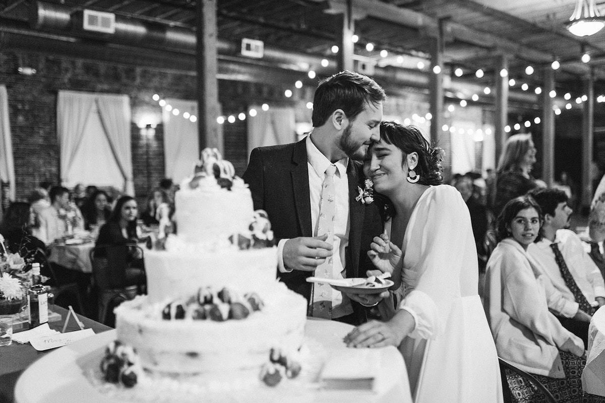 Bride snuggles into groom's shoulder, and he turns into her forehead