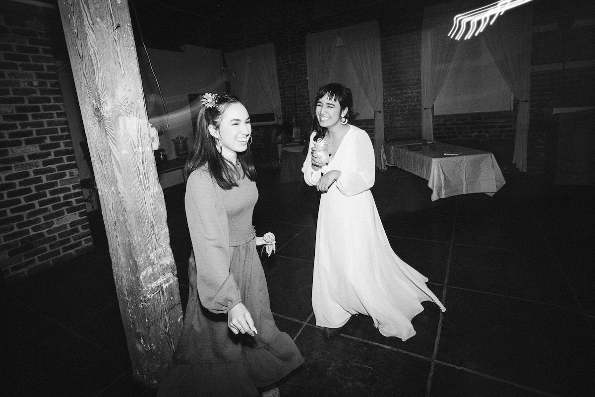 Bride and bridesmaid dance alone in a corner