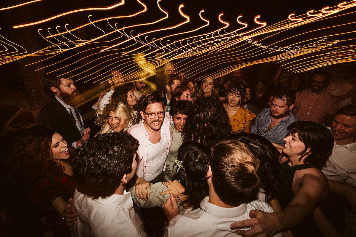 Group of friends form a tight cluster under lights