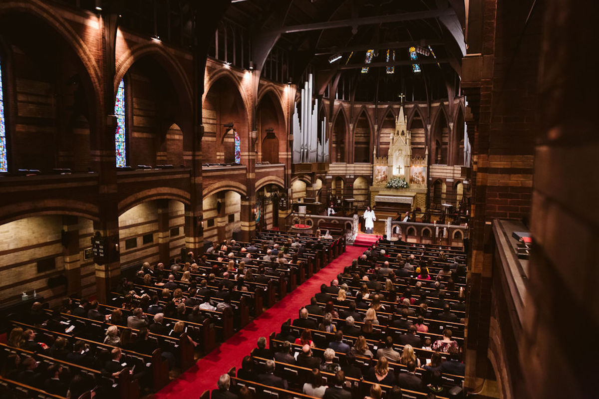 Sanctuary with brick walls, wooden pews, and red carpet of St. Paul's Episcopal Church in Chattanooga, TN