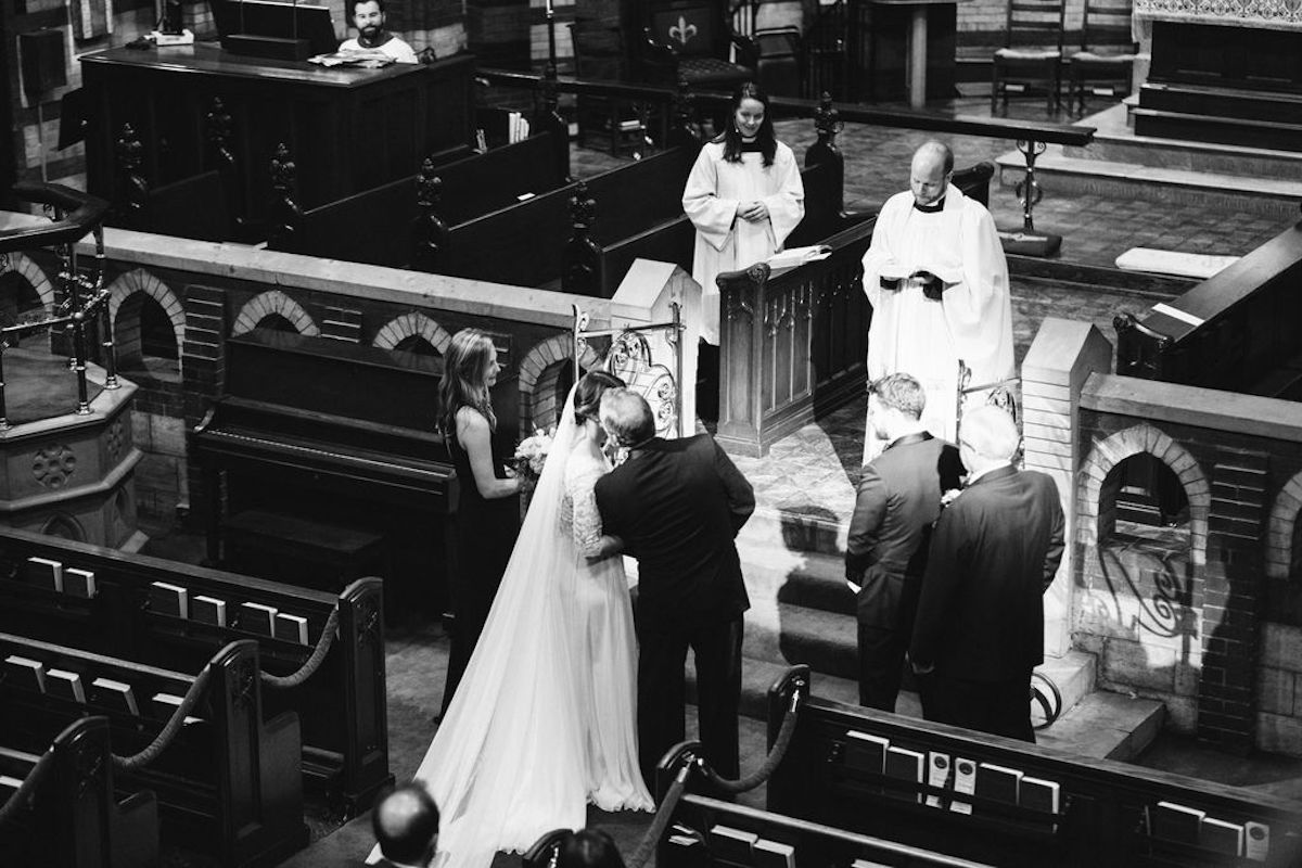 Priest and attendants watch father kiss his daughter's cheek at the altar of St. Paul's Episcopal Church in Chattanooga, TN