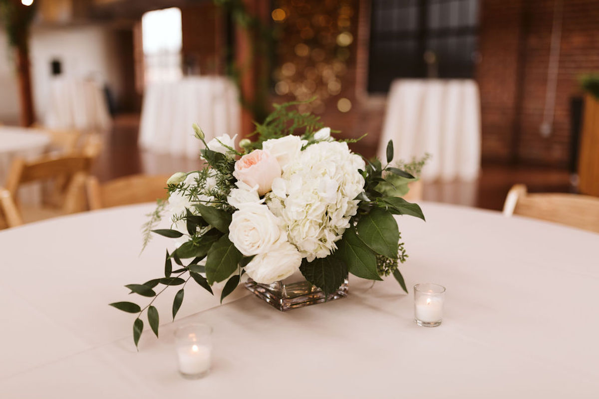 Tabletop vase with bouquet of white hydrangeas, peonies, roses and pink peony with greenery