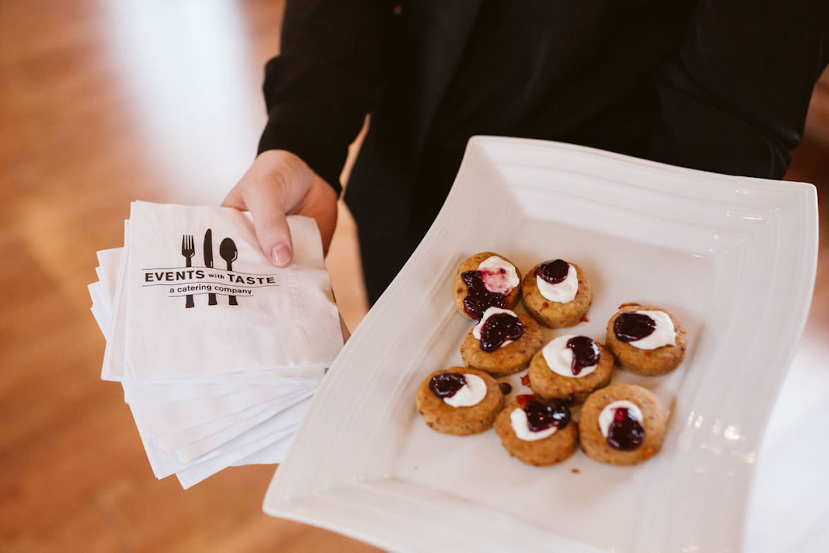 Platter with cream and jam-topped biscuits next to "Events with Taste" napkins