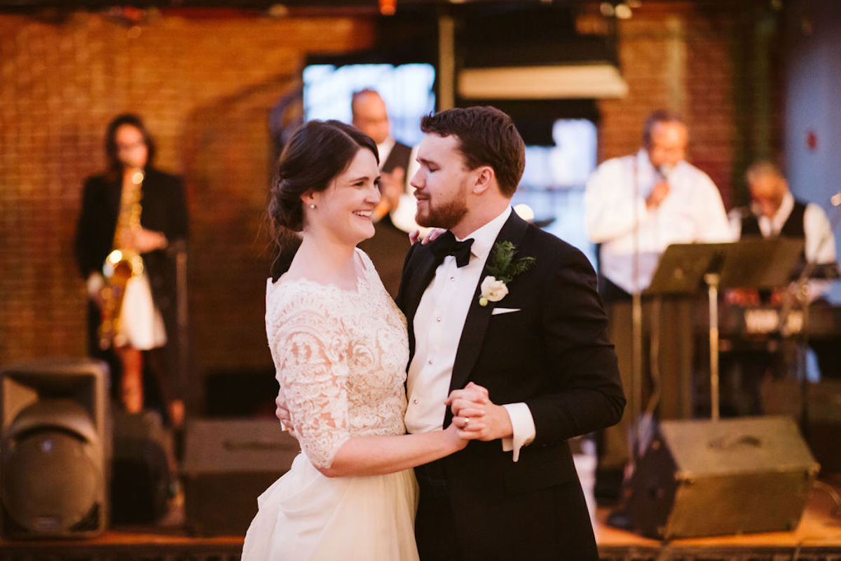 Groom sings to bride during their first dance while live band plays behind them.