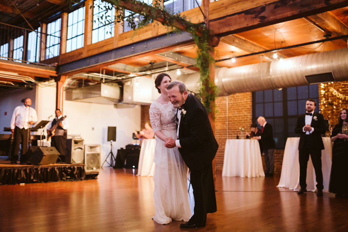 Bride and her father dance under exposed beams and ductwork at wedding at The Turnbull Building in Chattanooga TN
