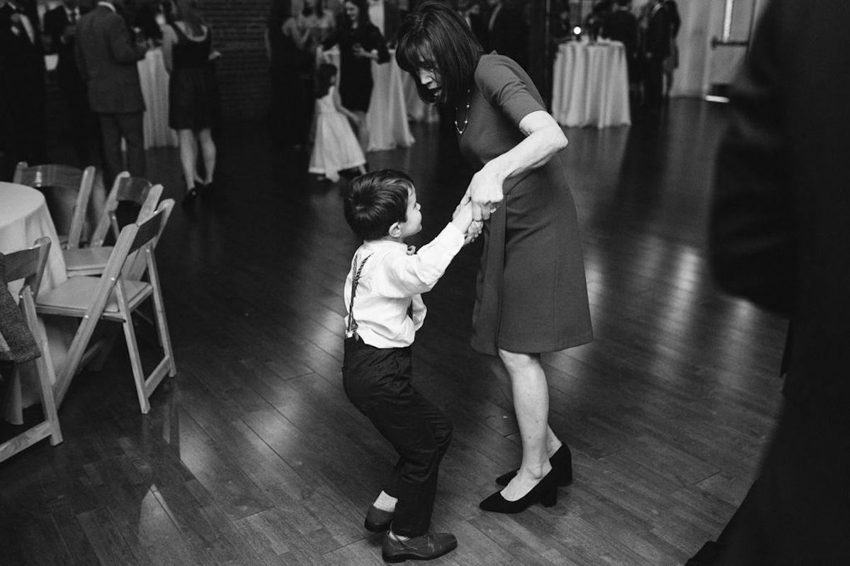 Woman and small boy dance on wooden dance floor
