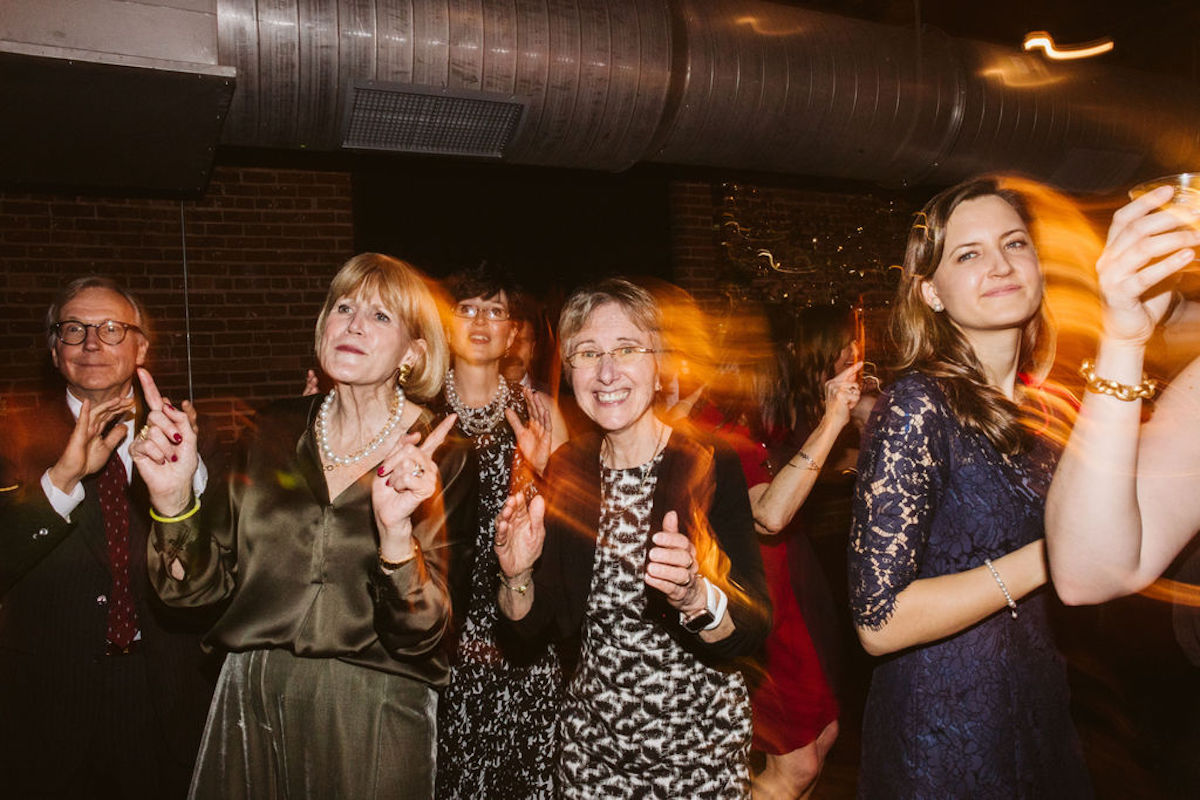 Wedding guests dancing under industrial exposed ductwork