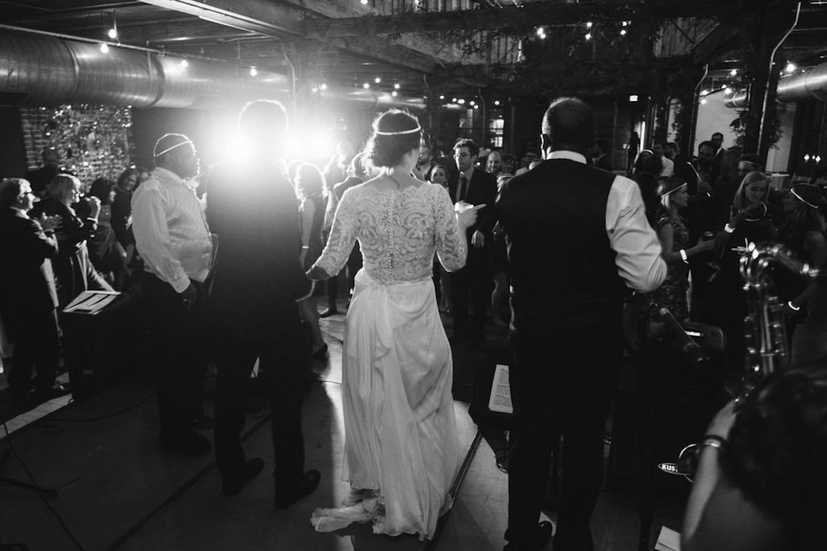 Back of bride as she's onstage with a band, speaking to wedding guests at The Turnbull