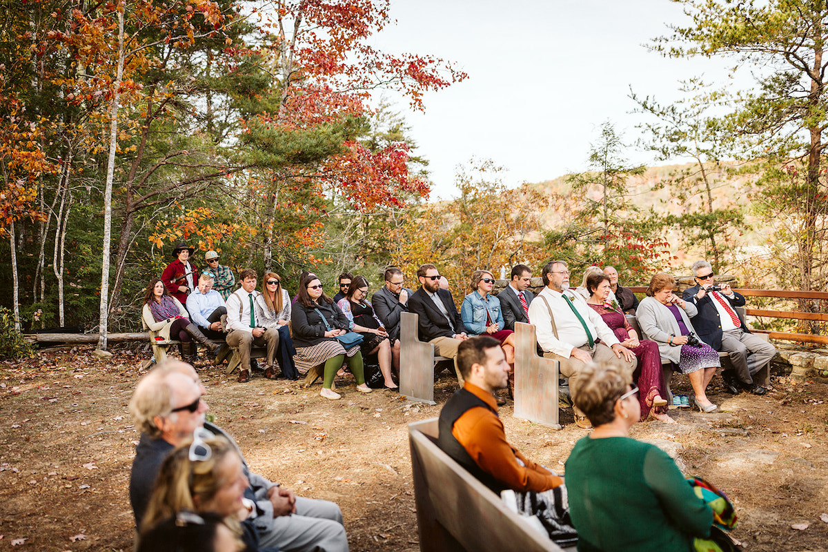 guests sit on benches at Fall Creek Falls State Park for intimate autumn wedding