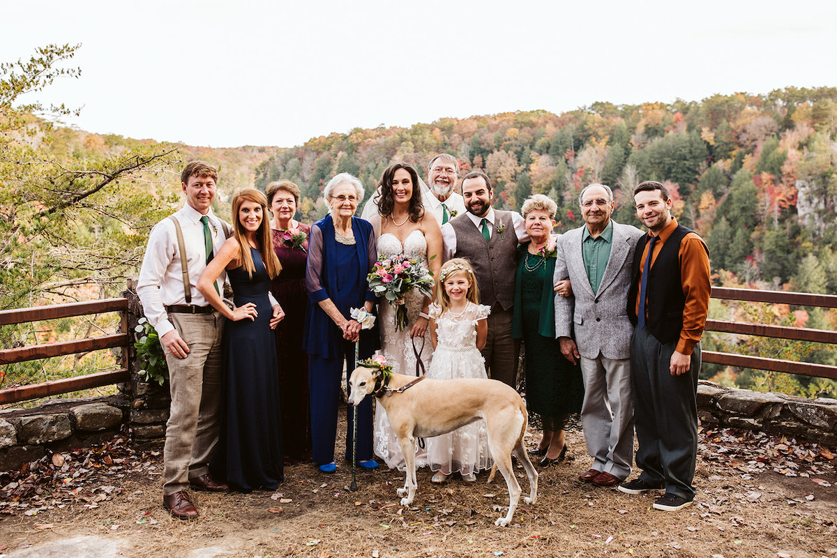 bride and groom pose with their family in front of Fall Creek Falls State Park overlook in Tennessee