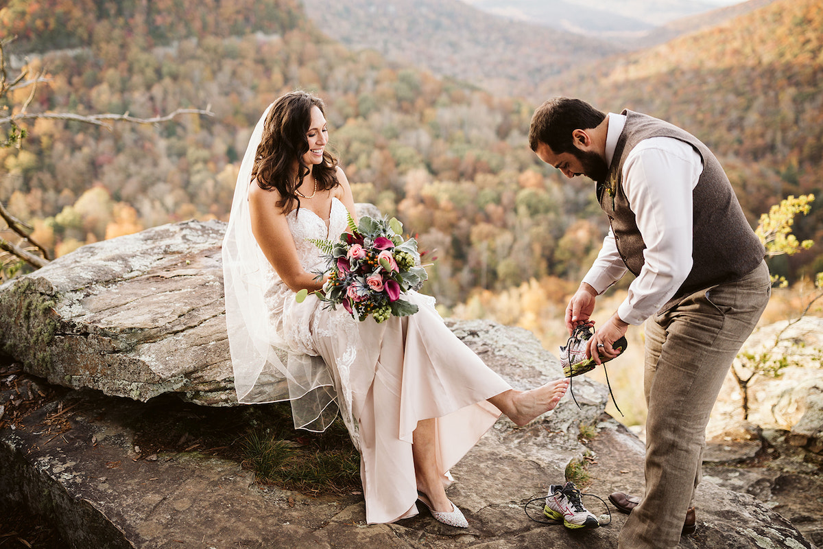 groom helps his bride change into hiking shoes for their photos at Fall Creek Falls waterfall