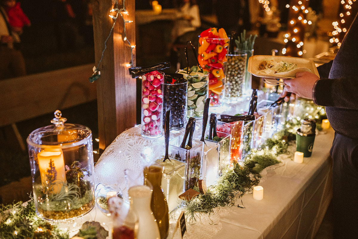 buffet vegetables line tables under string porch lights