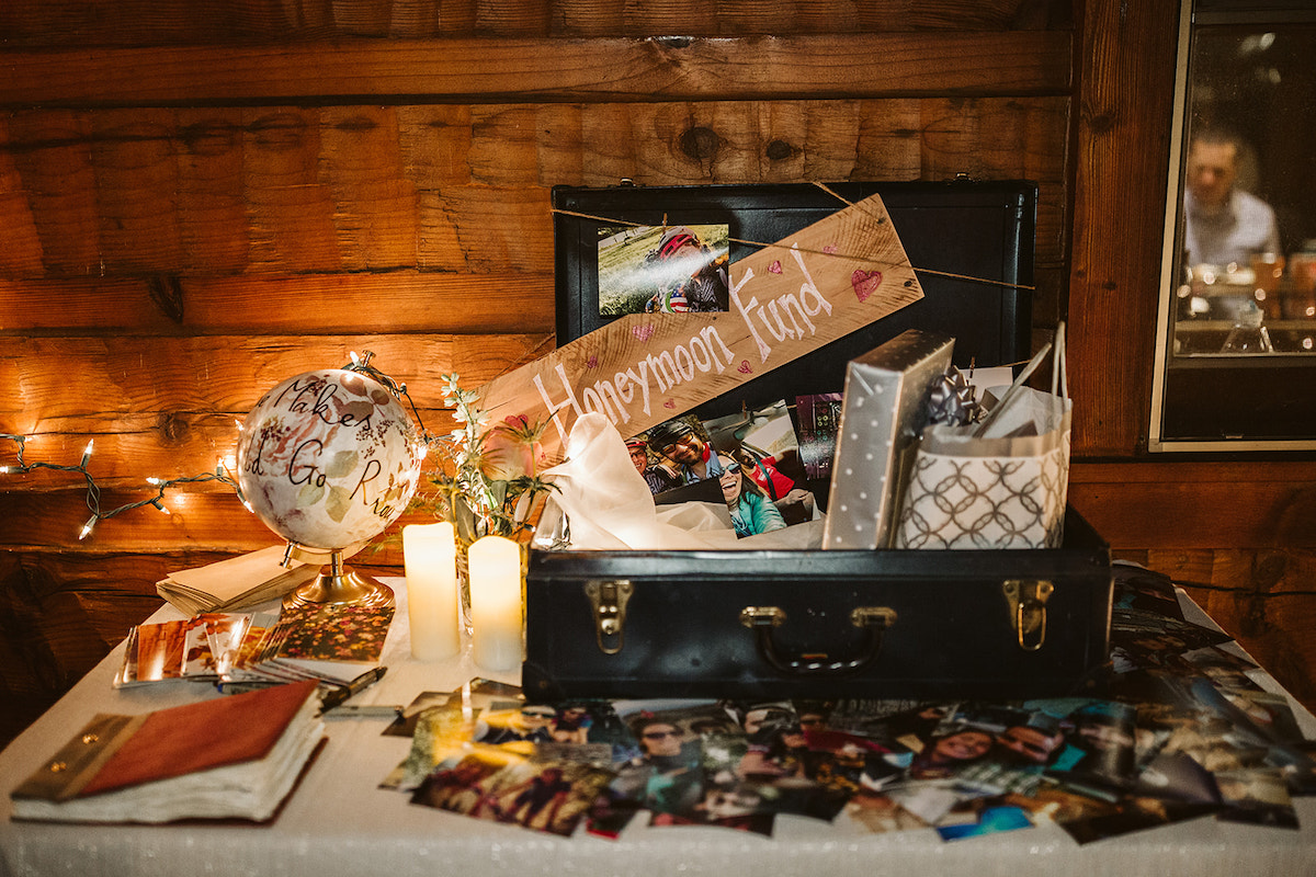 open suitcase sits on a table for cards and gifts and the guestbook for guests to sign