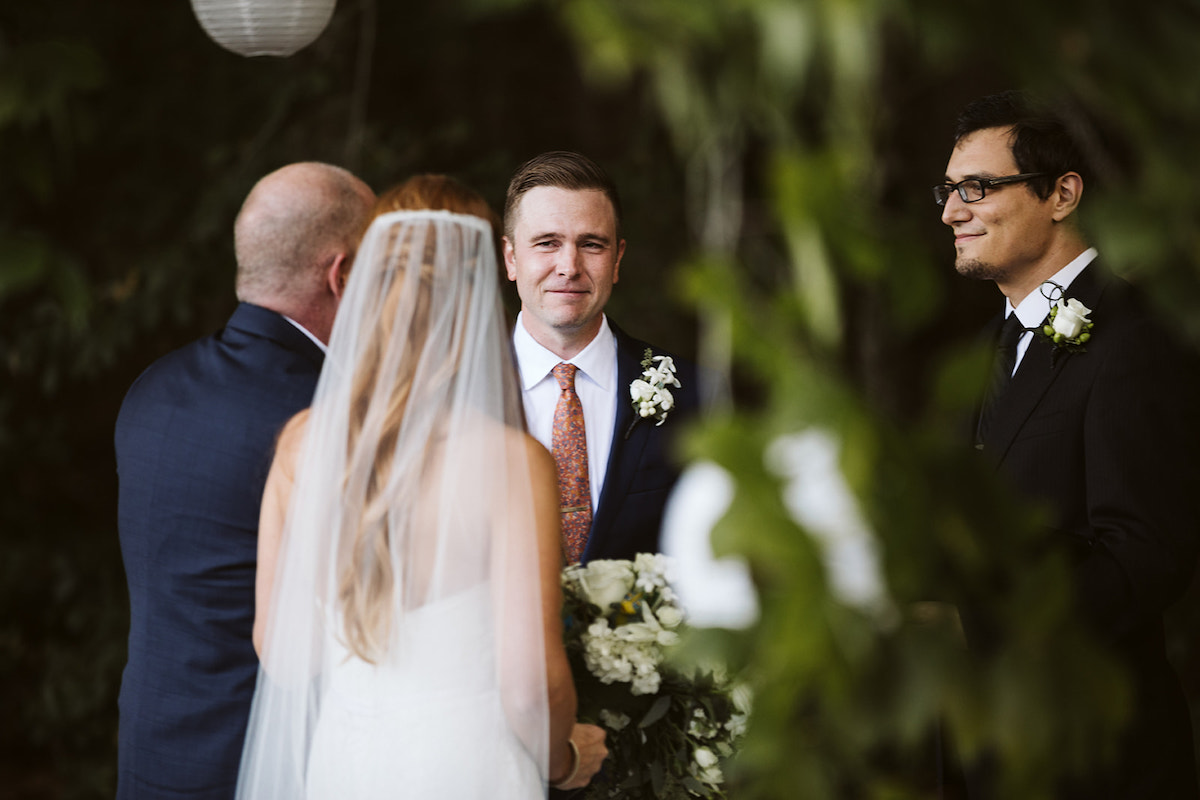 groom and officiant smile at bride as her father stands with her at the Chattanooga farm wedding ceremony