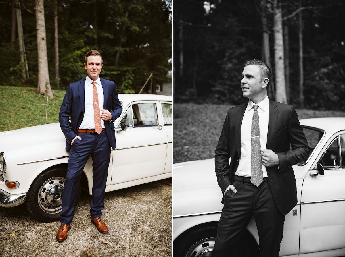 groom stands next to antique white Volvo, his hand holds onto his suit coat