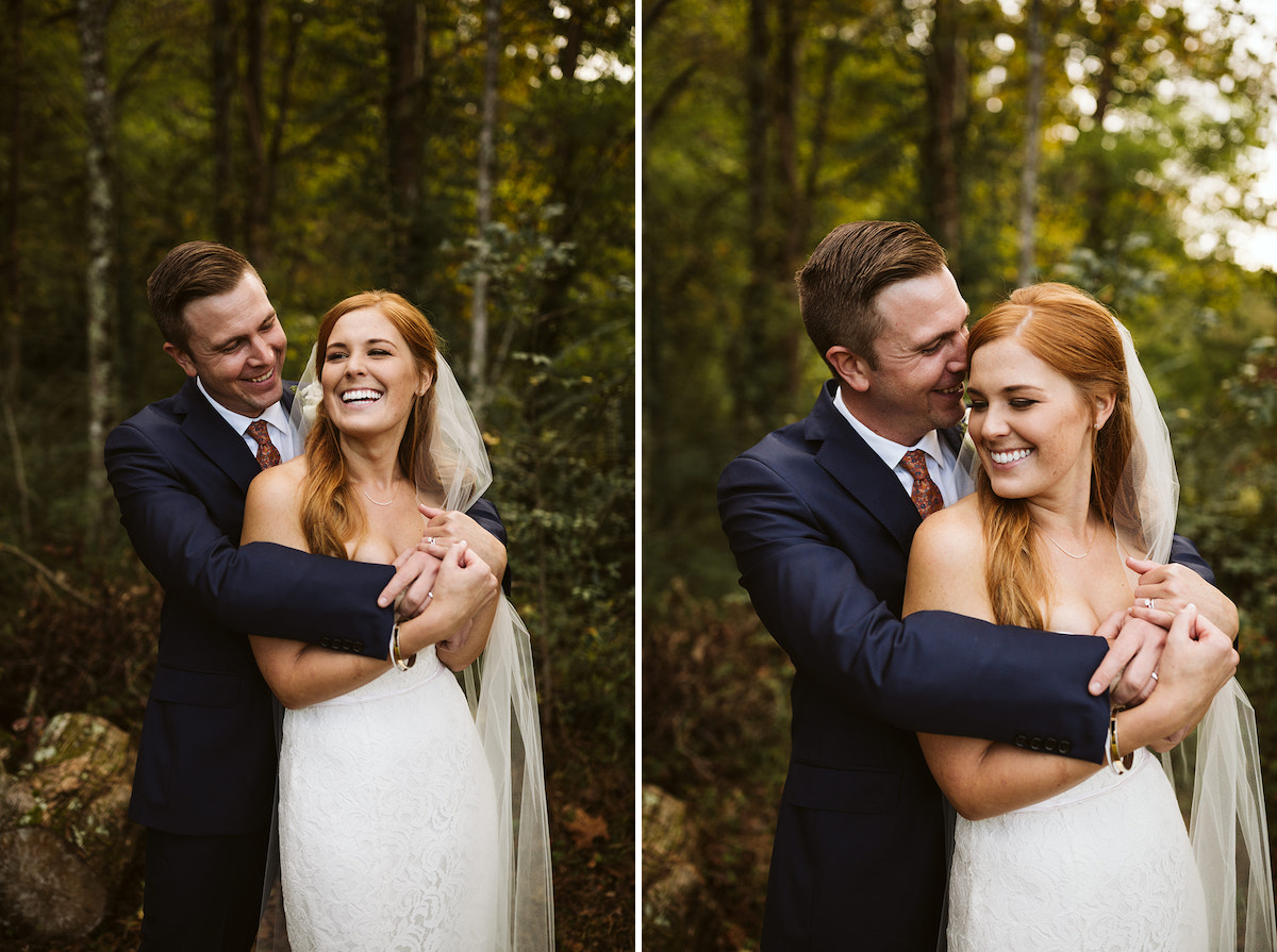 groom in dark blue suit hugs bride in strapless dress from behind as they laugh