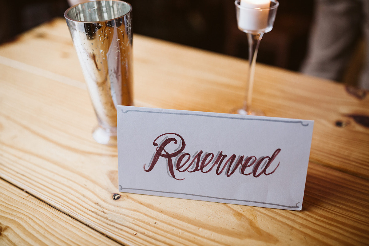 Hand-printed Reserved sign sits on a wooden table