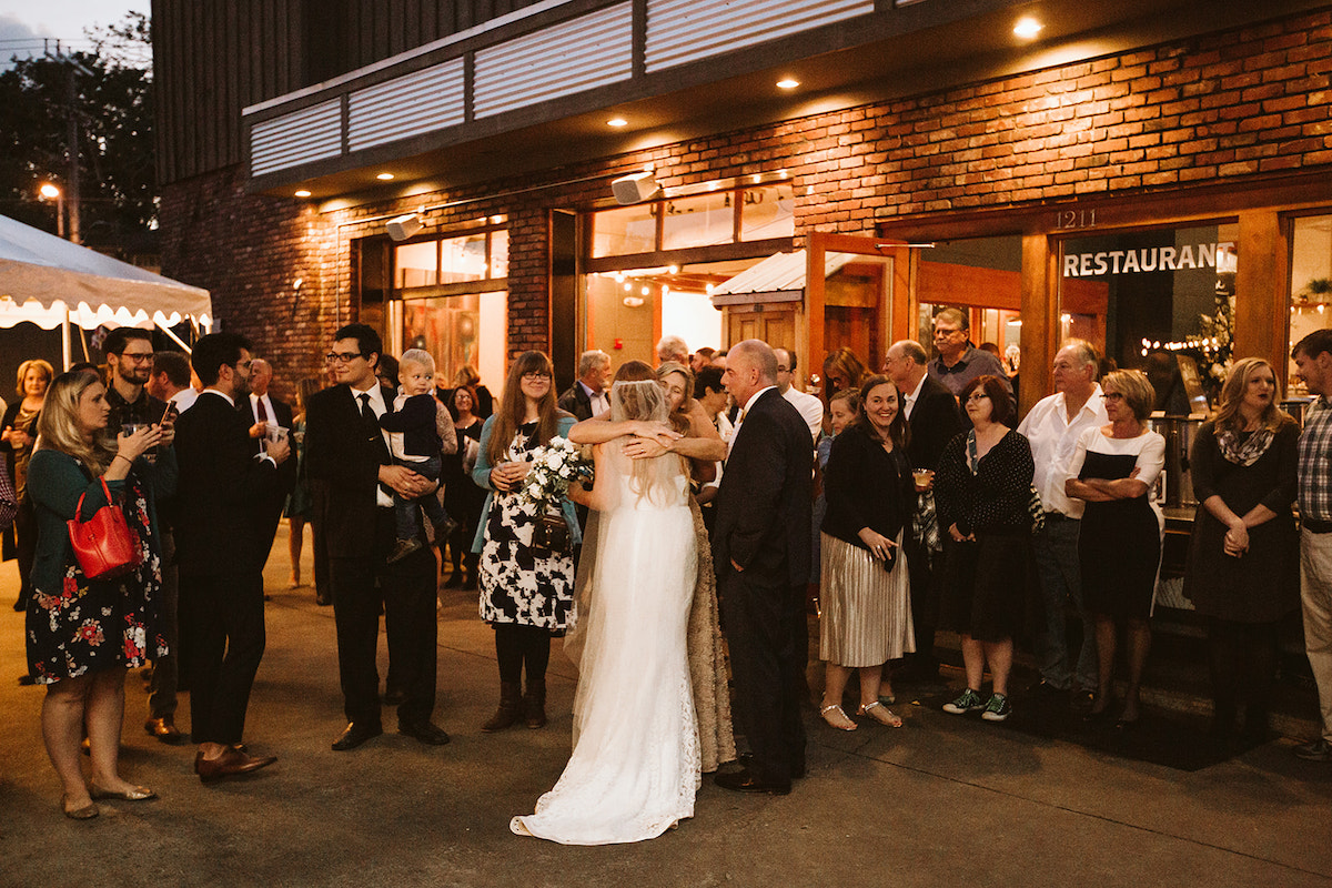 bride hugs wedding guests outside The Daily Ration