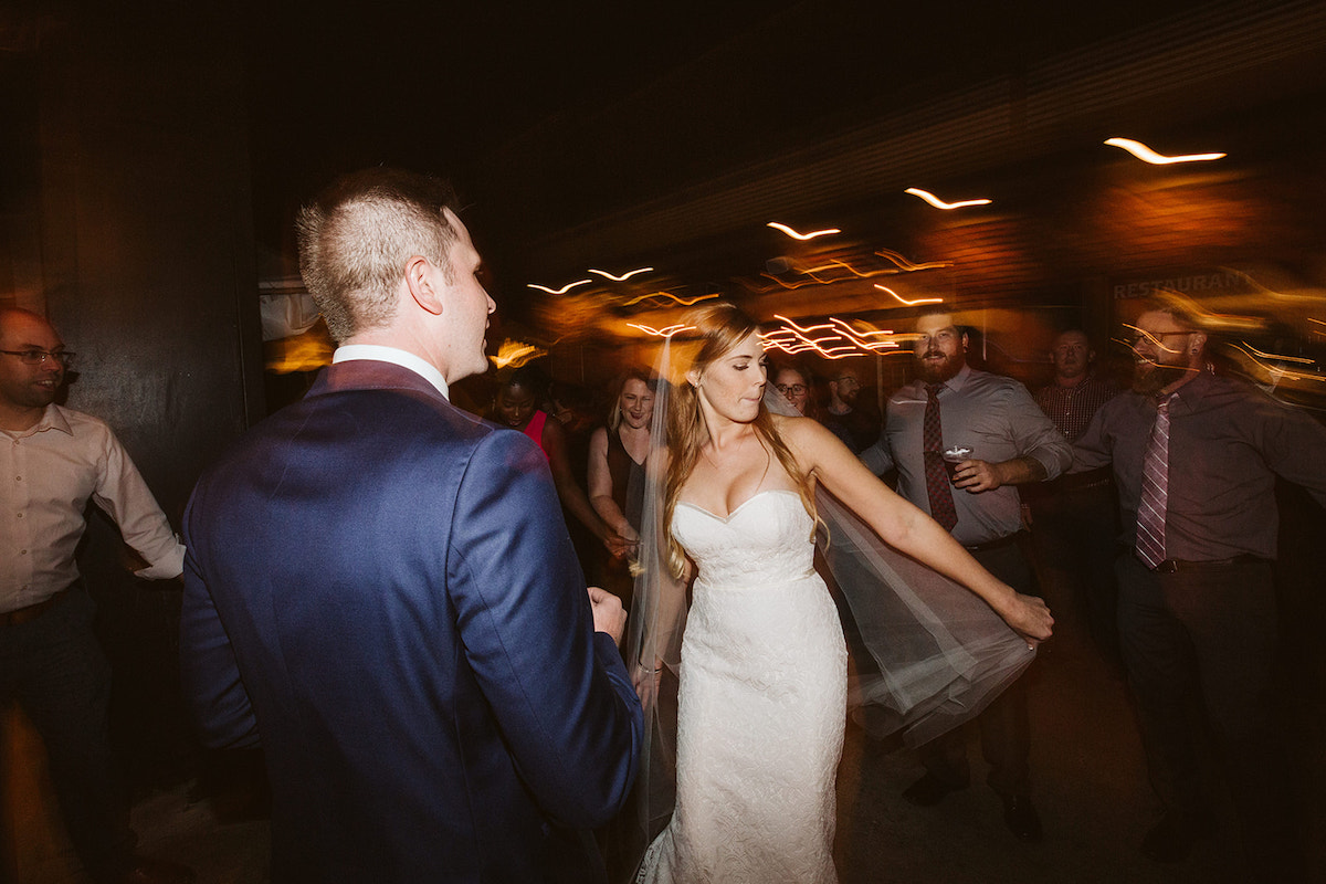 bride and groom dance with guests at their wedding reception at The Daily Ration in Chattanooga