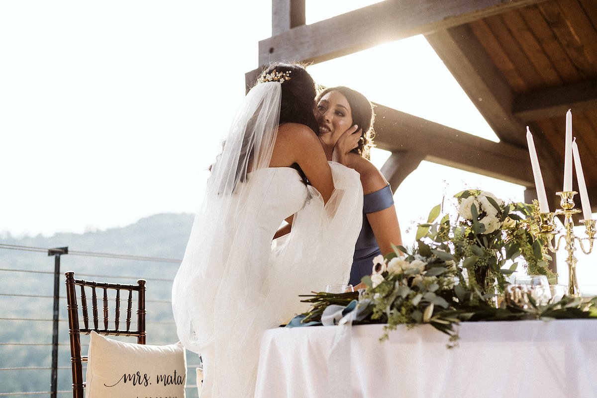 bride kisses matron of honor on the cheek