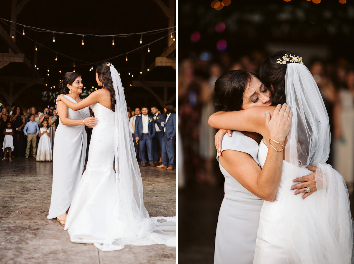 Bride and her mother hug and share a dance while wedding guests watch