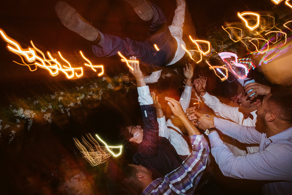 grooms friends throw him into the air as they dance