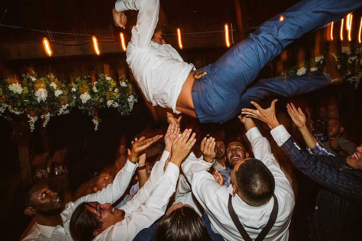 grooms friends throw him into the air as they dance