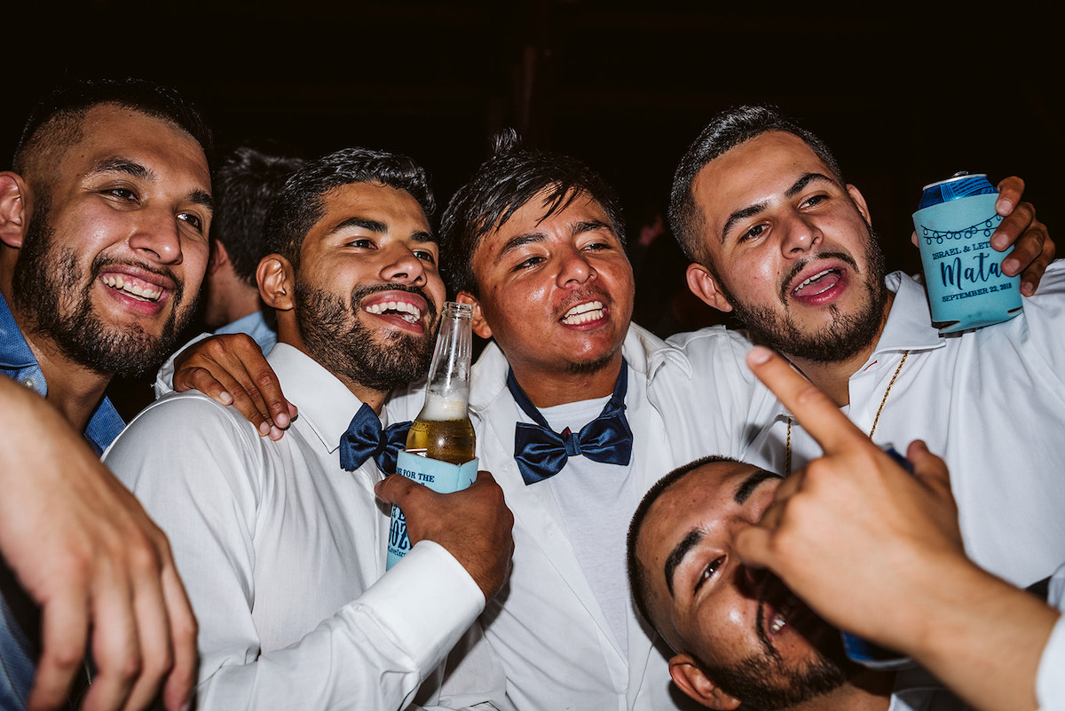 groomsmen and friends laughing together and posing for selfies