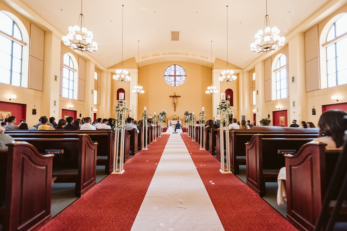 dark pews, red carpet, and bright interior of St Josephs Catholic Church in Dalton Georgia
