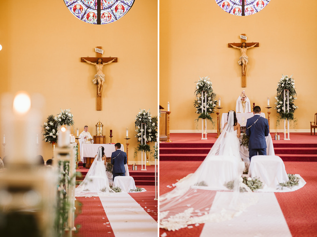 bride and groom kneel on pillows at altar with wedding lasso rosary around their shoulders while priest prepares communion