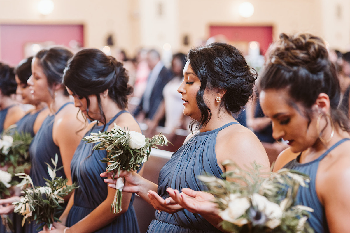 bridesmaids bow their heads in prayer