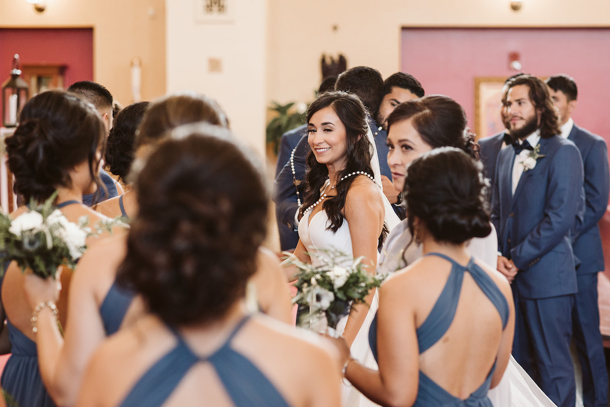 wedding party gathers around bride and groom