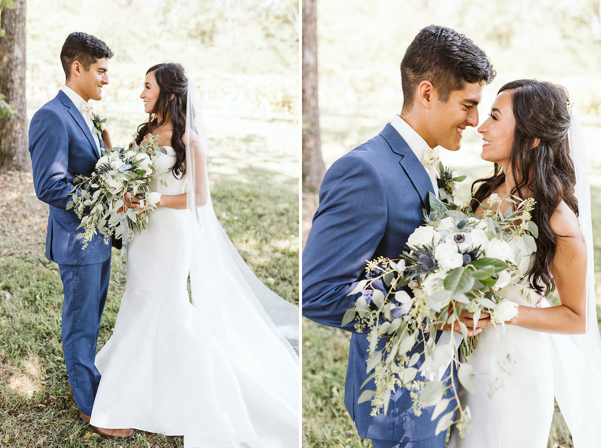 bride and groom face each other smiling. together they hold her large bouquet of white flowers and greenery