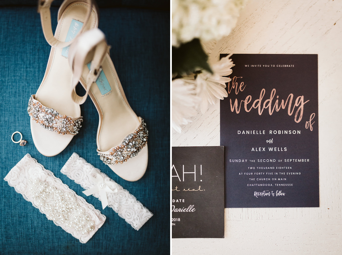 black wedding invitation lies next to white flowers on a white counter