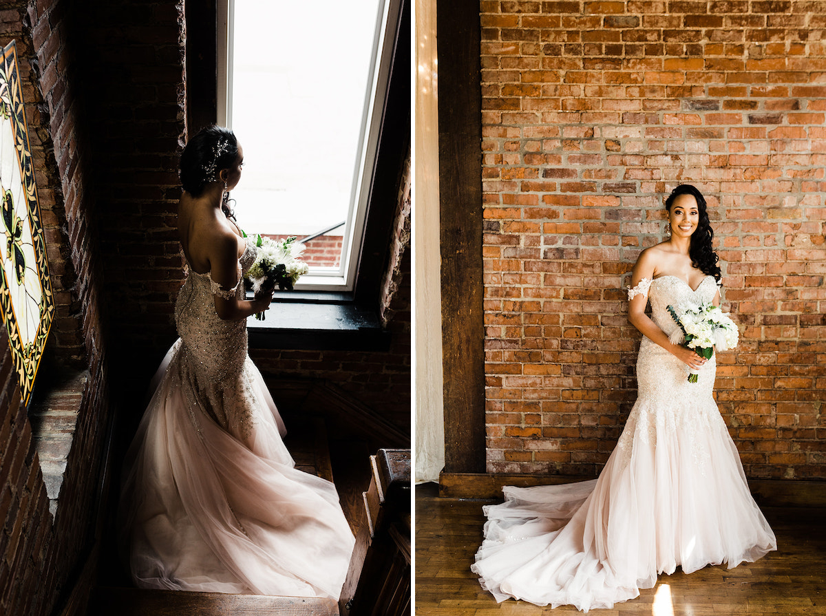 bride stands in the shadows on a wooden staircase landing, looking out the bright window