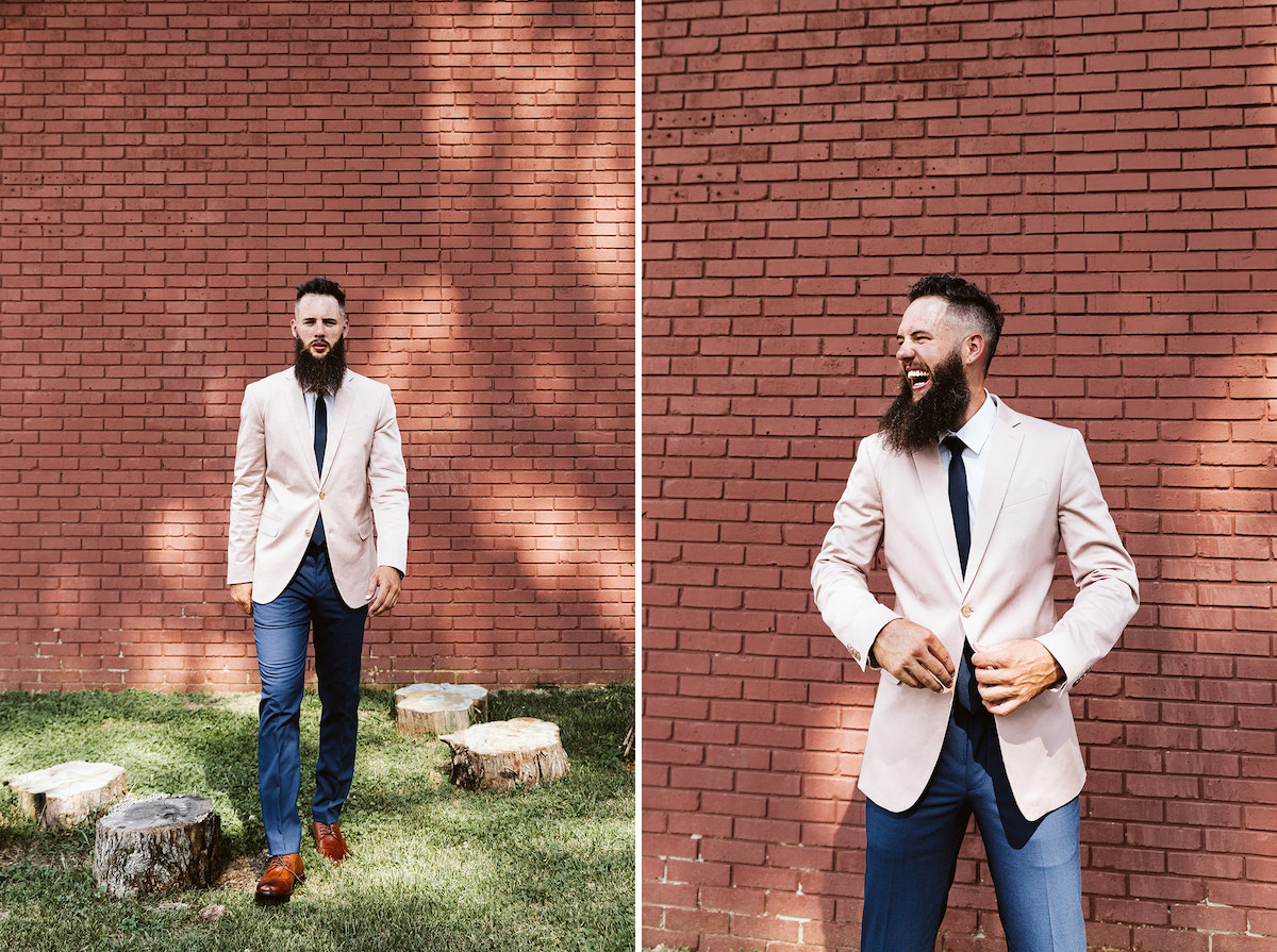 groom with long, dark beard wears a pastel pink suit coat and deep blue trousers
