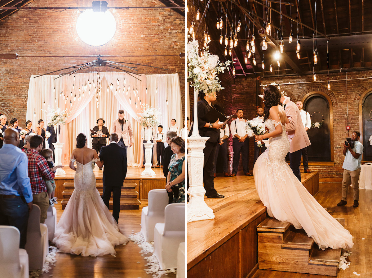 groom escorts bride up wooden stairs under a modern chandelier at The Church on Main