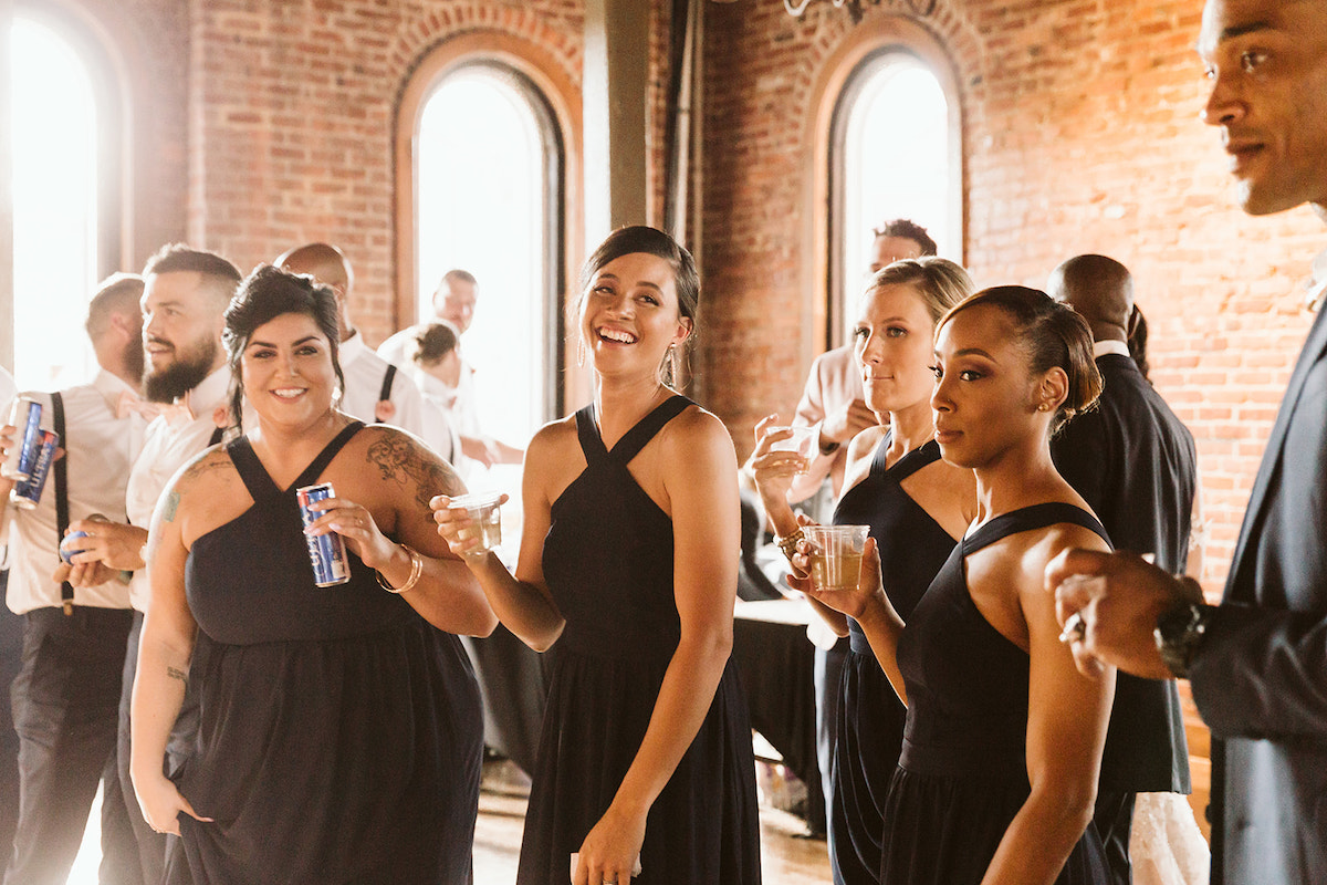 bridesmaids stand in front of tall, arched windows at The Church on Main in Chattanooga, TN