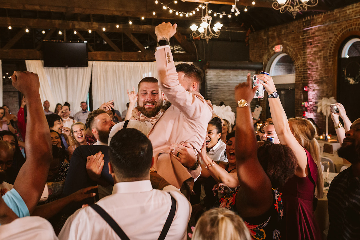 tall man with bowtie carries his friend in the middle of dancing crowd at The Church on Main in Chattanooga, TN