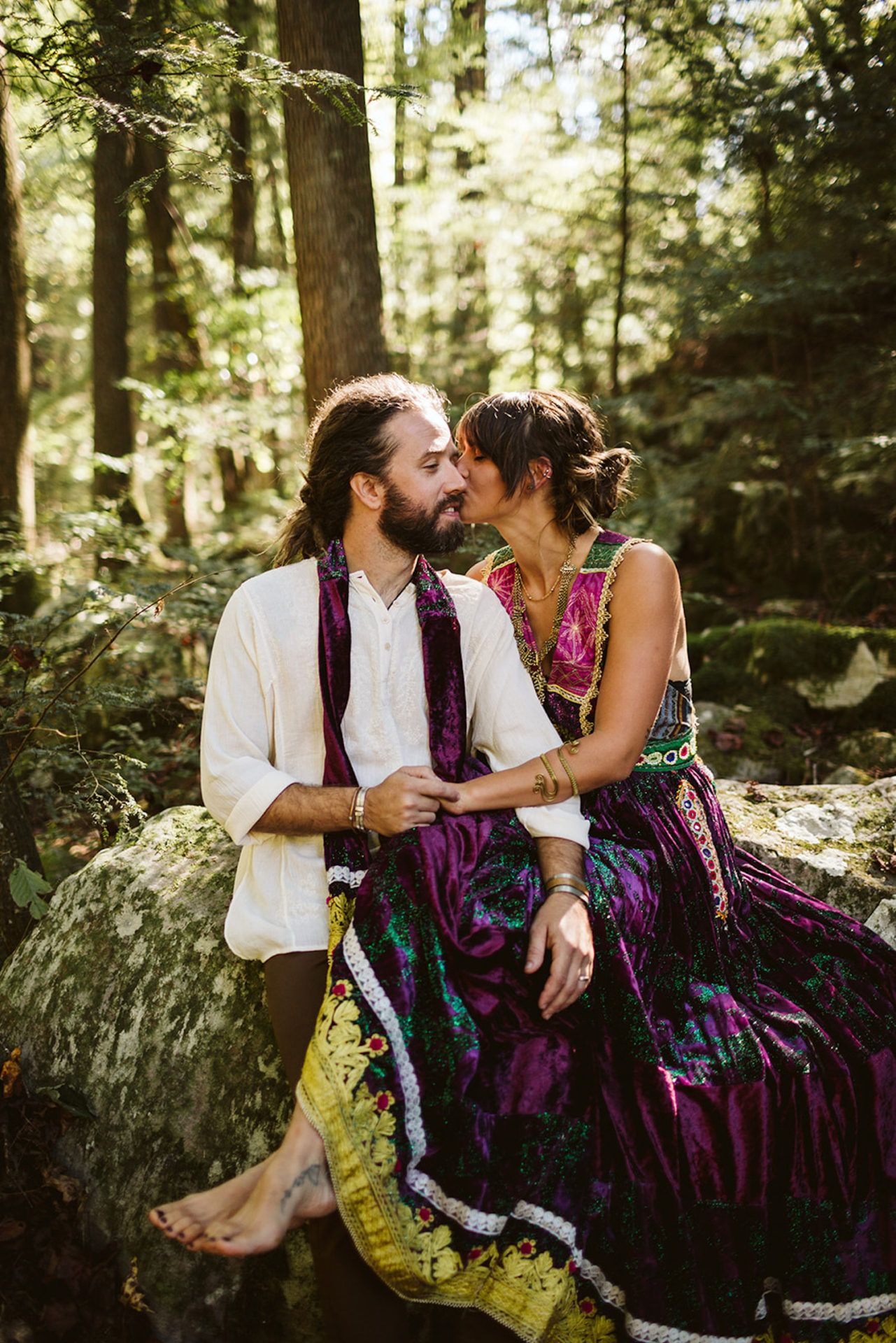 man and woman snuggle on large rocks for their Bohemian wedding photos at Foster Falls in Chattanooga, Tennessee