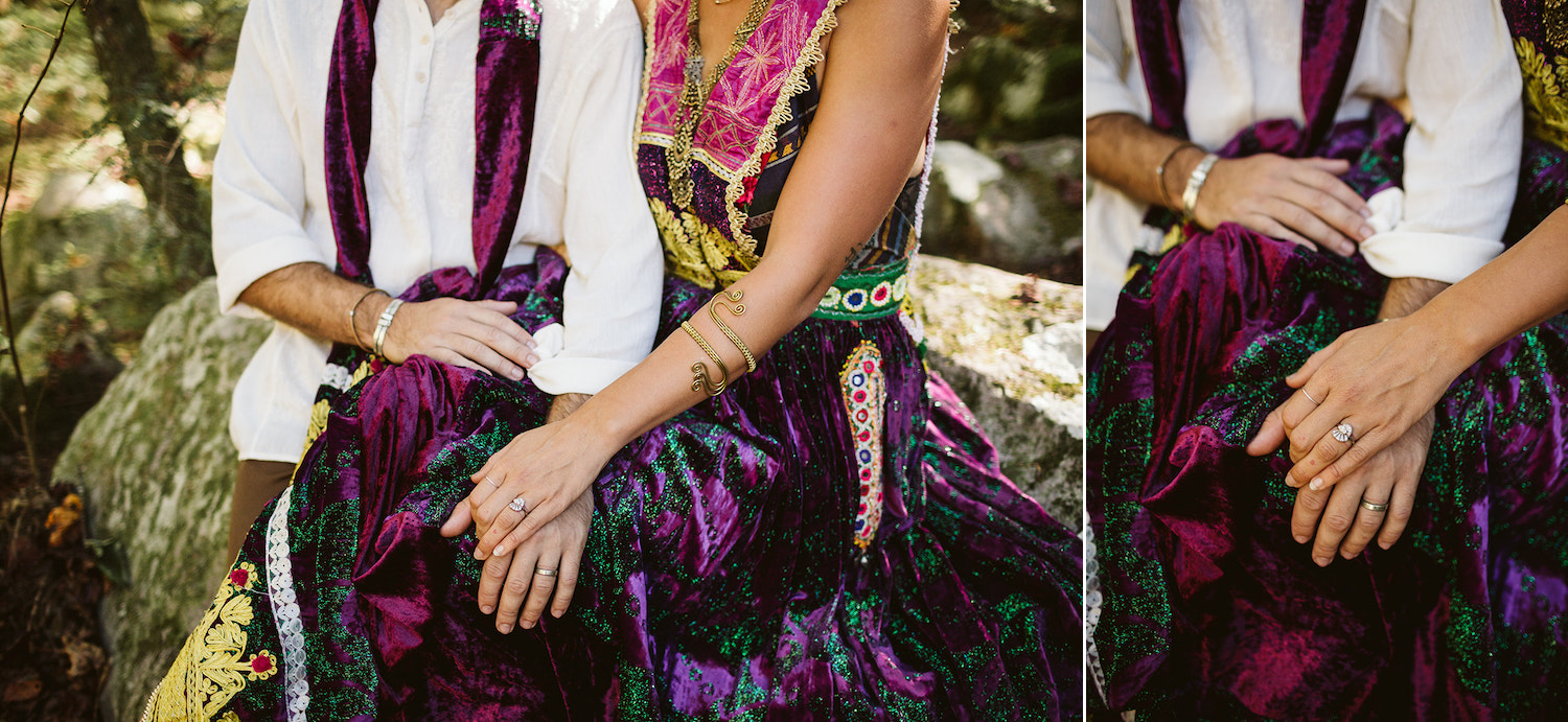 man and woman dressed in colorful Bohemian style dress snuggle on large rock