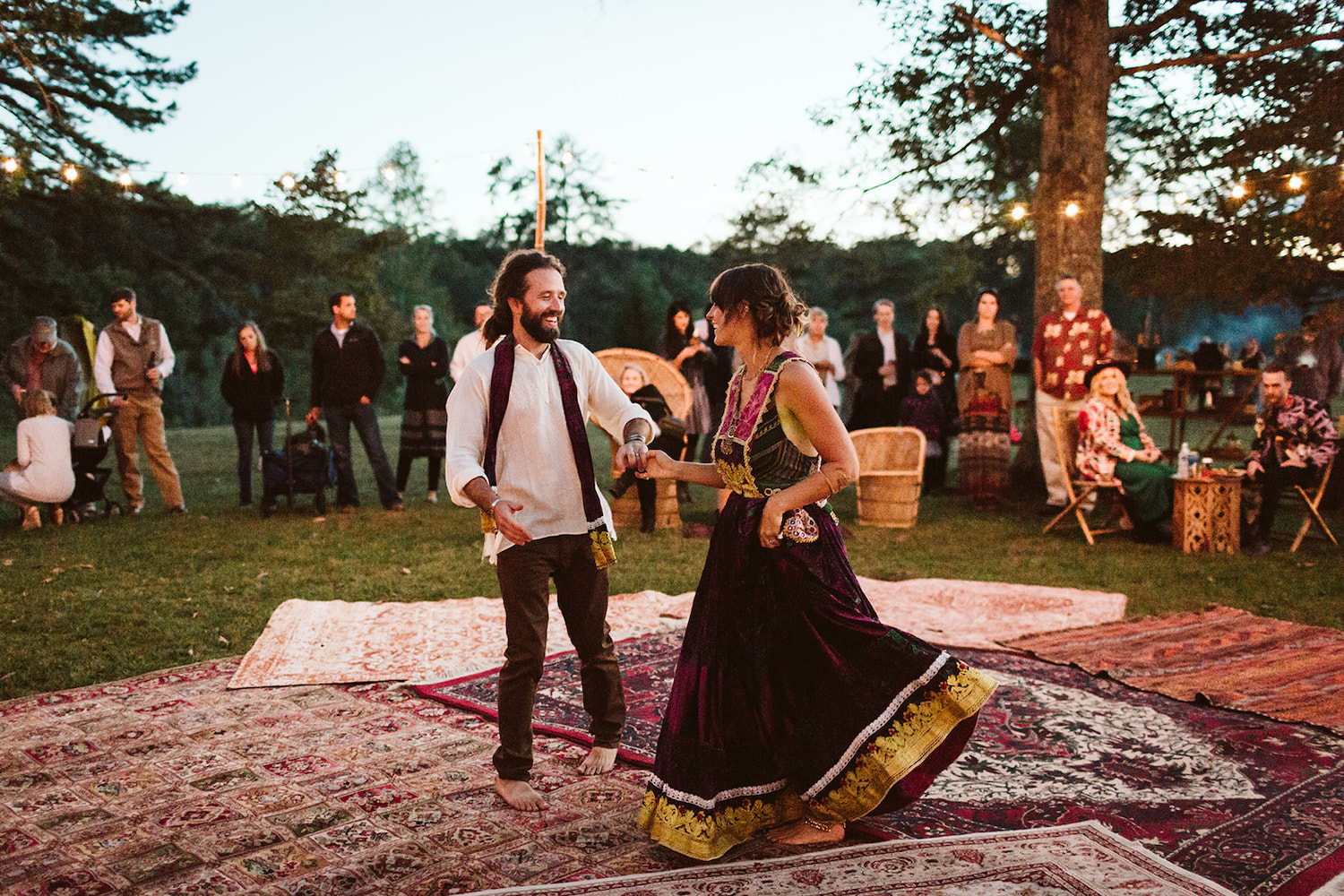 man and woman dance on outdoor dance floor made of Oriental rugs and their Bohemian festival wedding reception in Chattanooga
