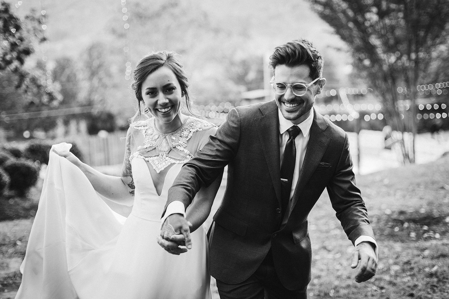 bride and groom smile while holding hands