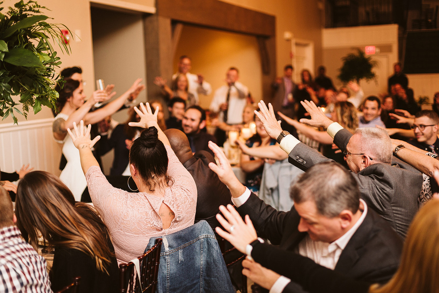 wedding guests stretch their hands toward bride and groom during Lookout Mountain wedding reception toasts