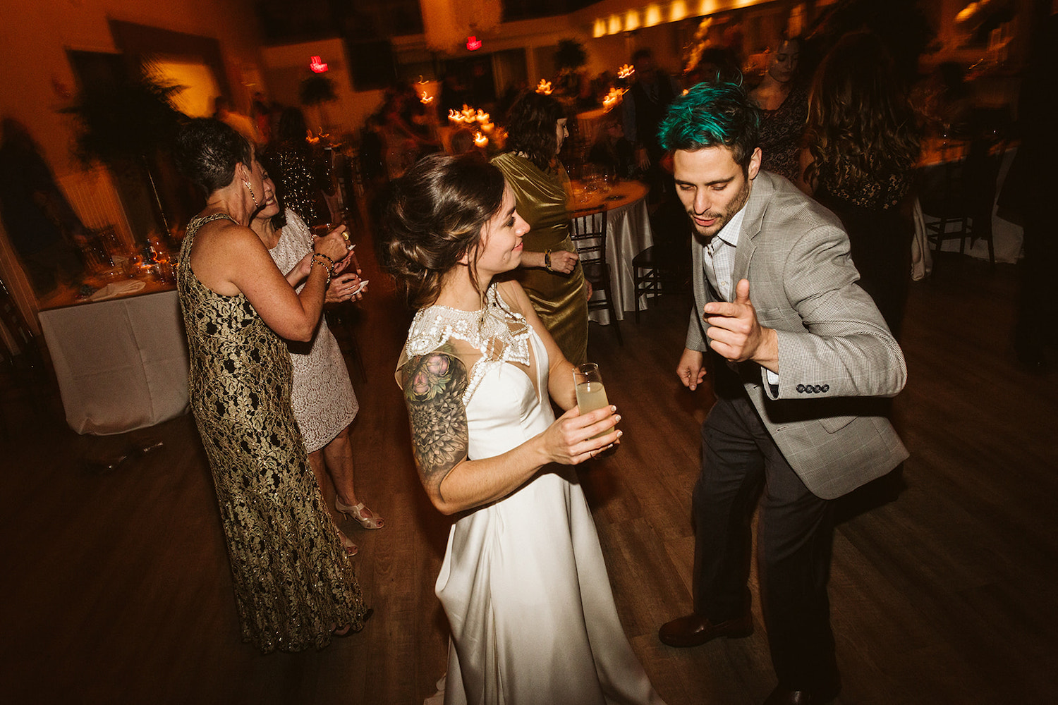 bride holds a cocktail and dances with a man at her Lookout Mountain wedding reception