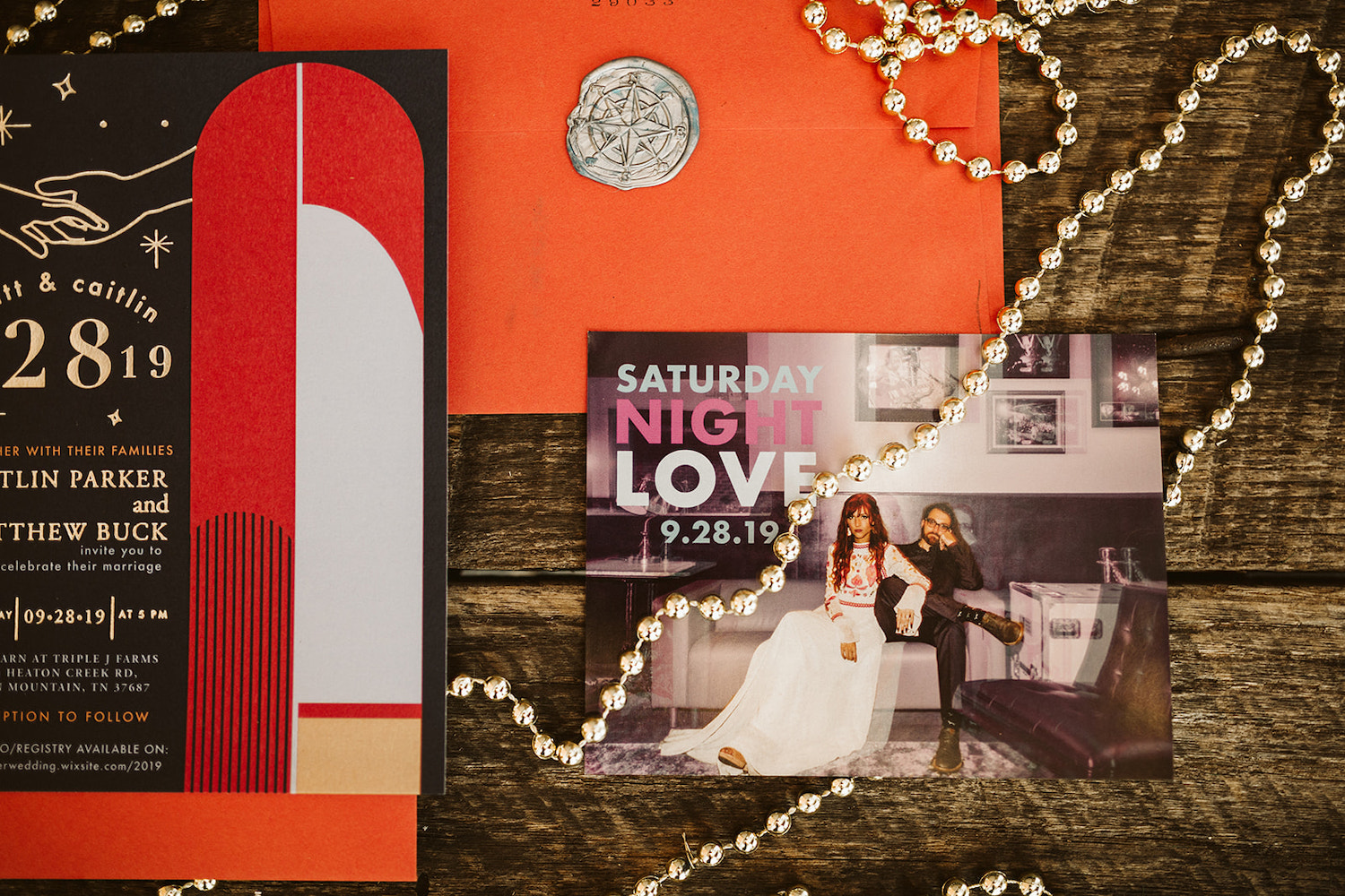 bright, bold wedding invitation and save-the-date cards draped with bead necklace